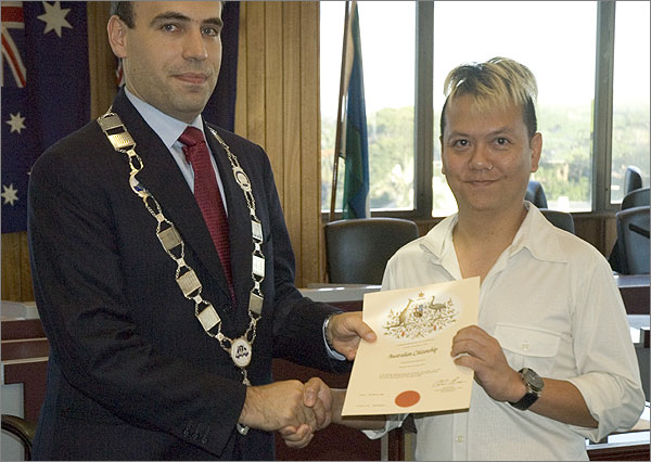 Photograph of Mayor of Marrickville, Dimitrios Thanos, with Trinn Suwannapa, holding an Australian Citizenship certificate