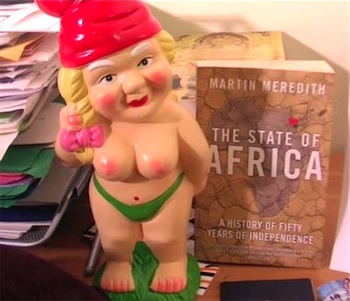 Topless gnome Gnaomi, standing near the book The State of Africa by Martin Meredith, from the opening to Stilgherrian Live episode 48