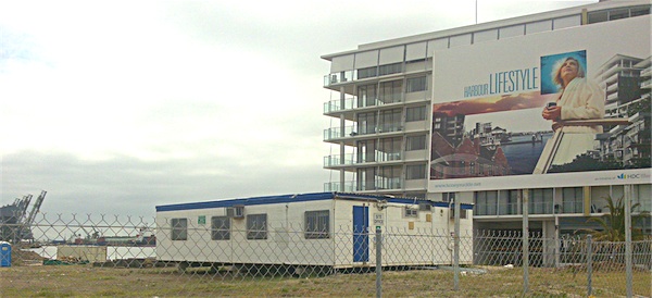 Photograph of newly-built apartment and signage reading Harbour Lifestyle