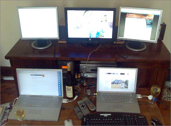 Photograph of election night set-up with 2 x laptops, each with 2 screens, and a TV
