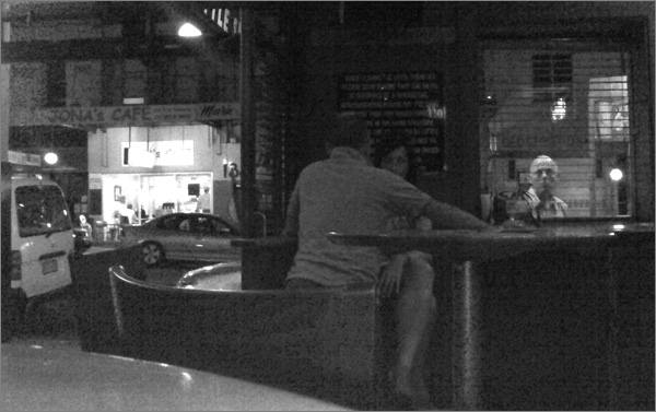 Photograph of man peering thru pub window (very indistinct)